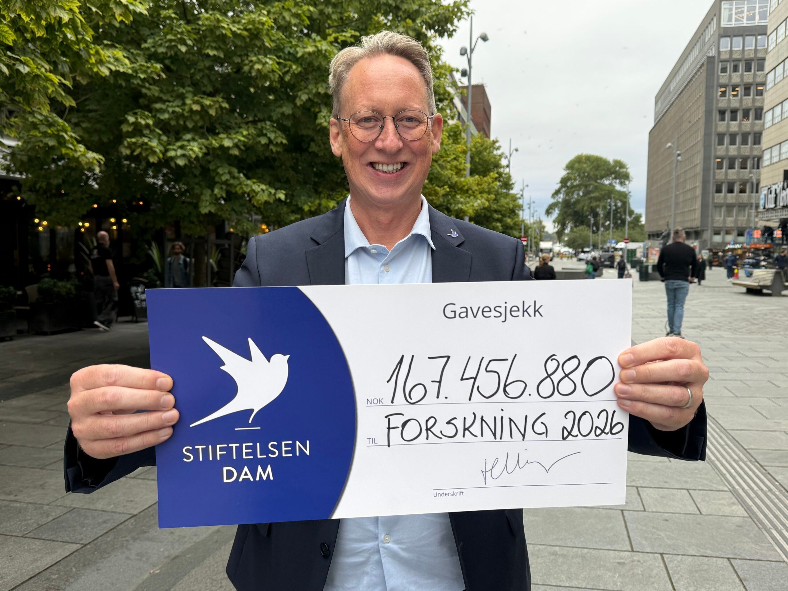 Generalsekretær i Stiftelsen DAM med gavesjekk til organisasjoner som har fått pengestøtte